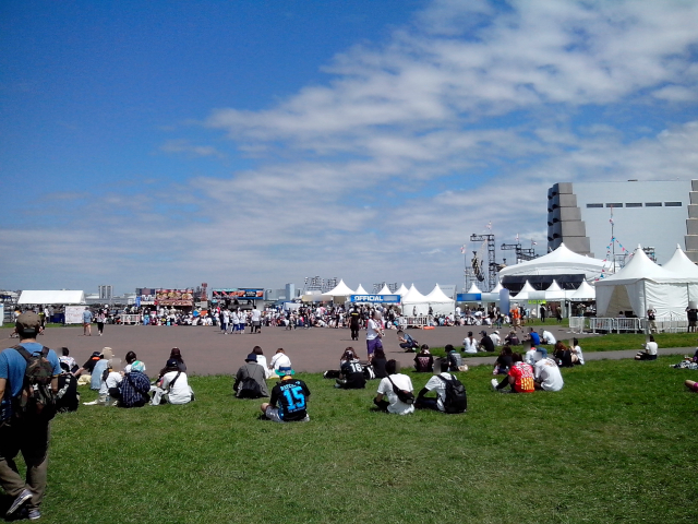 音楽フェスBAYCAMP 2016の会場。開演前の風景。芝生に腰掛ける人々と青空。